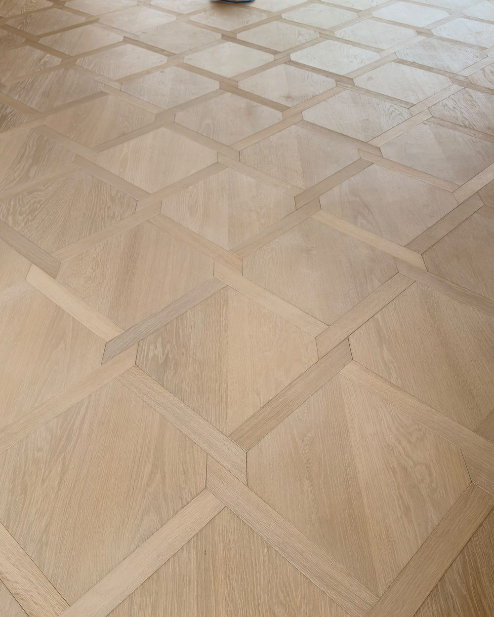 Close-up of a geometric parquet oak floor with precise inlaid borders